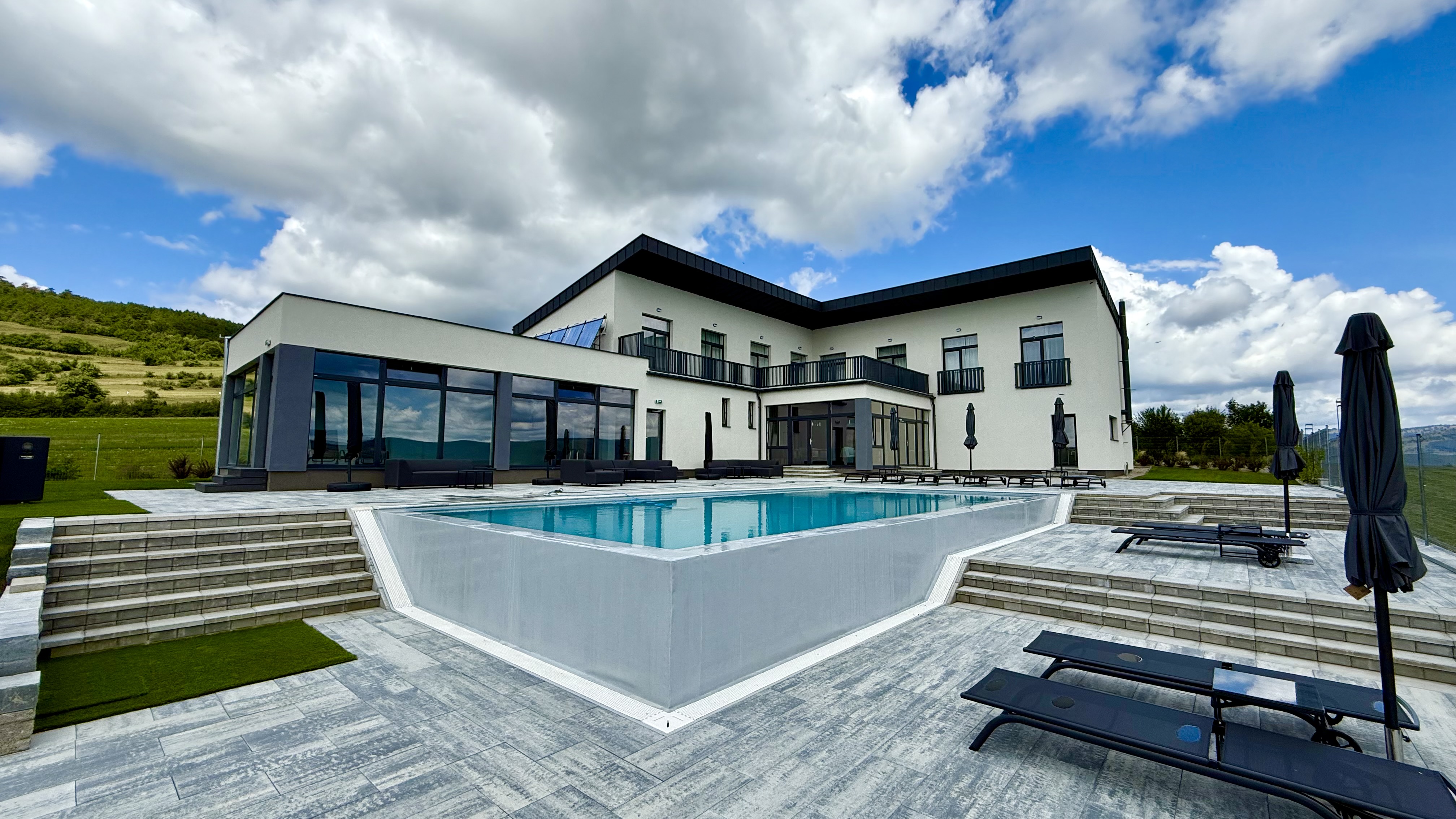 Villa Ambition exterior with outdoor pool and Transylvanian landscape