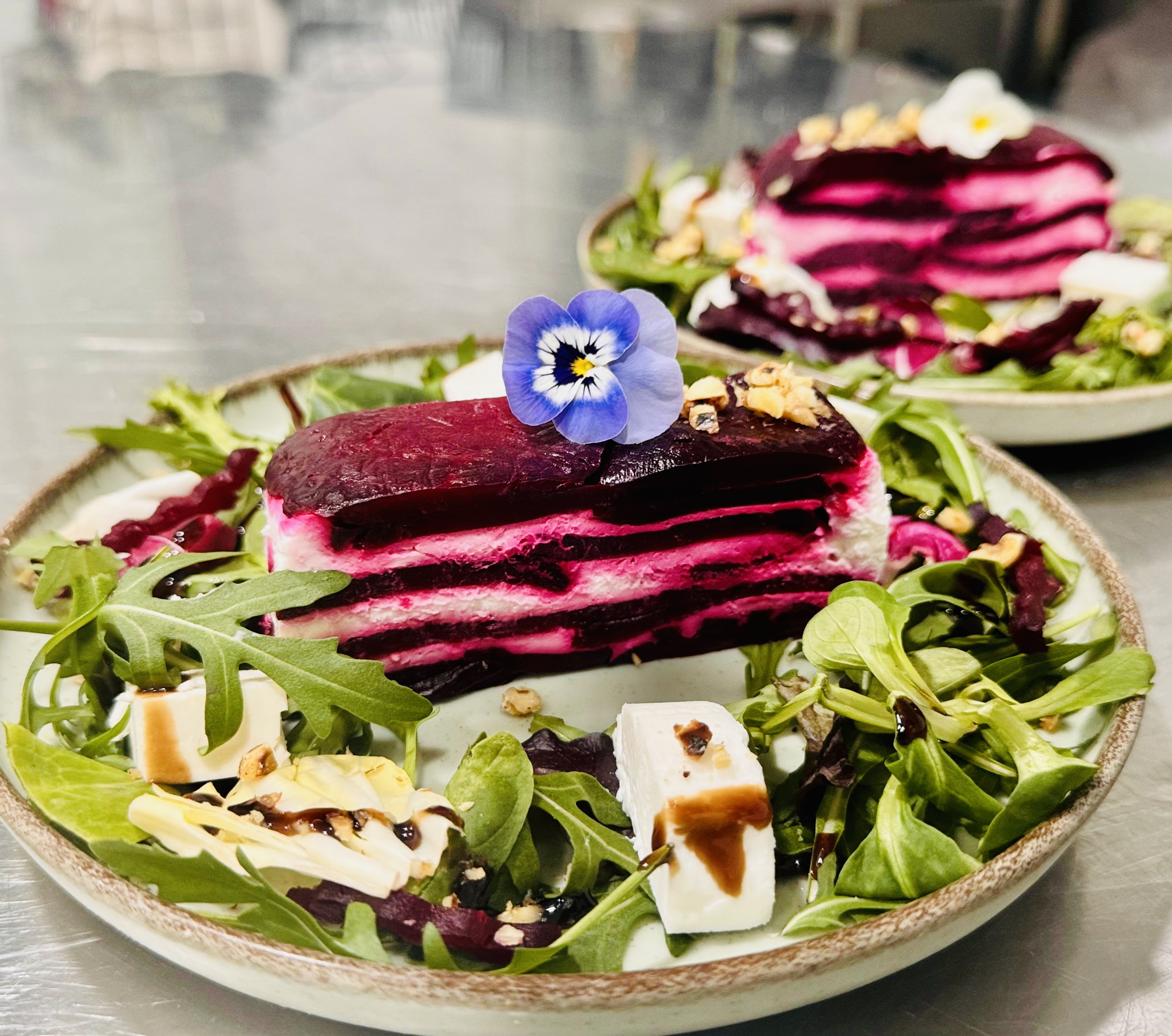 Beetroot and goat cheese terrine with arugula, edible flowers and balsamic drizzle